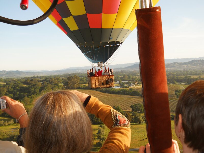 Guests toasting as a neighboring balloon drifts past the basket