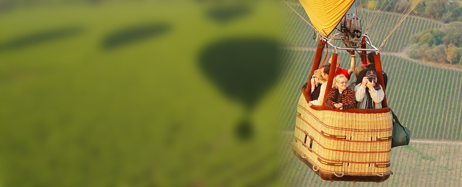 Guests photographing the vineyards from the basket of a Santa Rosa Ballooning flight