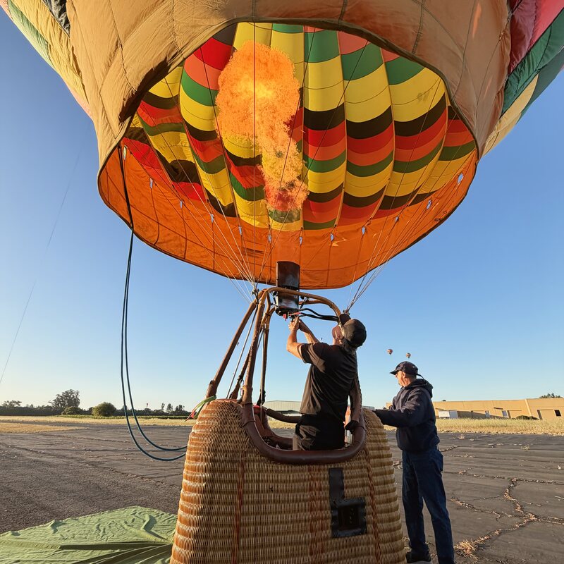 The burner firing as the envelope inflates at dawn